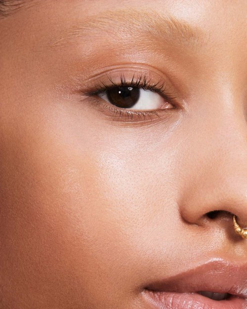 Närbild av en persons öga och del av ansiktet, som visar slät hud och naturlig makeup.