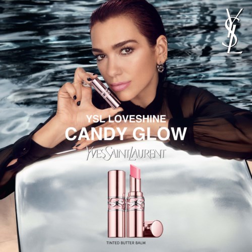 A woman with dark hair holds a lipstick near her face, water background, YSL logo, promoting candy-colored lip balm.