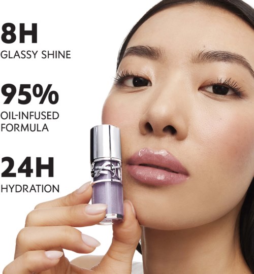 A woman with smooth skin holds a purple nail polish bottle, highlighting its longevity and hydration benefits.