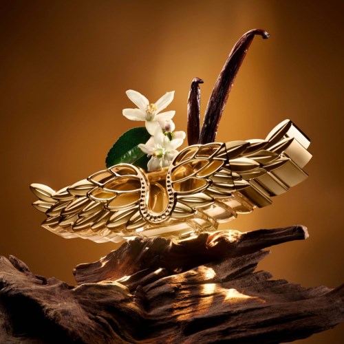 Eine goldene Flügel-schmuckstück mit weißen Blumen und grünen Blättern, auf einem Holzstück platziert.