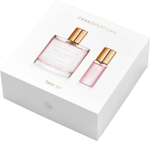 En vit låda med bild av en parfym och reseandral i rosa flaskor med guldkapslar, märkt Zarkoperfume Twin Set.