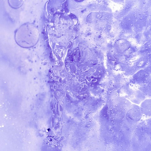 Close-up of icy, purple-hued surface with bubbles and cracks, resembling frozen water or ice.