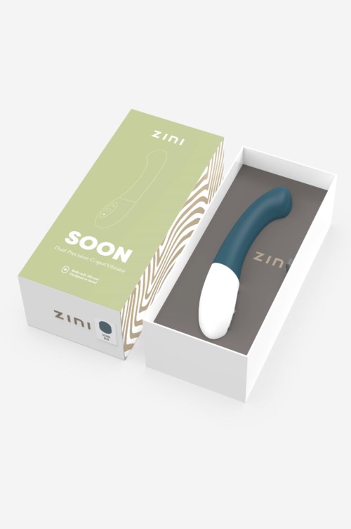 Ein blauer gebogener Gegenstand in einer weißen Box, mit Verpackung mit "ZINI SOON".