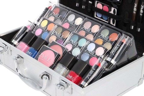 Make-upset met lippenstiften, nagellakken en oogschaduws in een witte koffer.