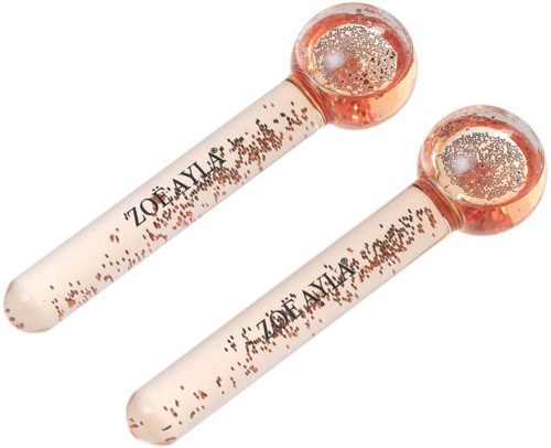 Twee jade rollers met roze handvat en ronde koppen gevuld met kleine goudvlokken. Ze worden gebruikt voor gezichtsbehandeling.