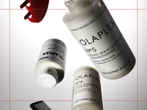 Tre flaskor med OLAPLEX hårvårdsprodukter, inklusive balsam, schampo och behandling, med en röd kam nära.