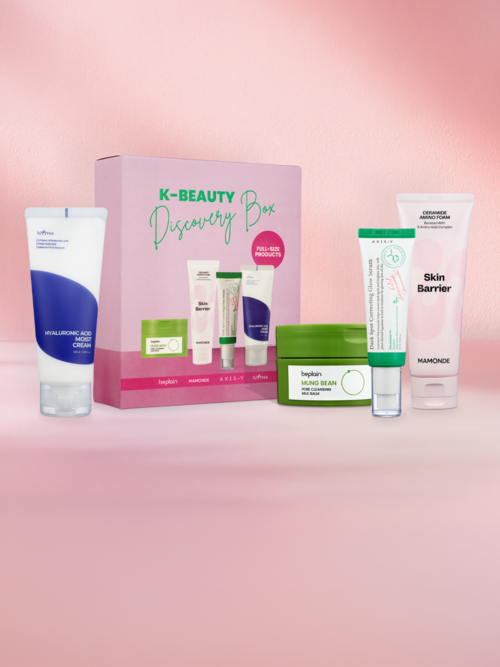 En hudvårdsuppsättning med flera krämer och rengöringsmedel framför en rosa box märkt K-BEAUTY Discovery Box.