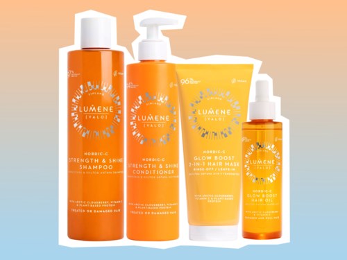Set med fyra orange hårvårdsprodukter som schampo, balsam, leave-in gel och spray med vita lock och etiketter.
