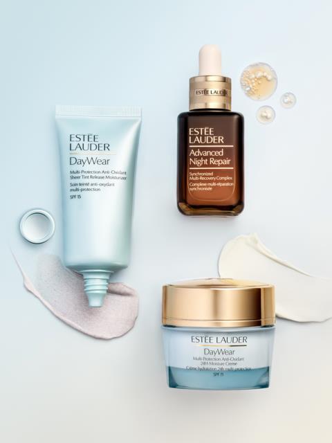 Hudvårdsprodukter inklusive en DayWear fuktighetskräm, Advanced Night Repair serum, och en DayWear kräm på ljus bakgrund.