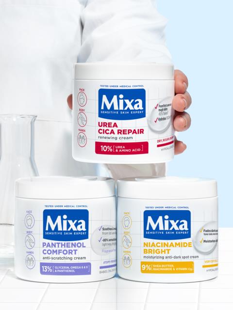 Three jars of skincare creams labeled Mixa, with different purposes and ingredients, arranged on a white surface.