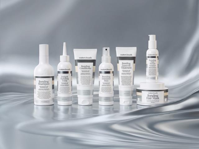 En samling hårvårdsprodukter inklusive schampo, balsam, behandlingar och mask, med vit förpackning på en silverglansig bakgrund.